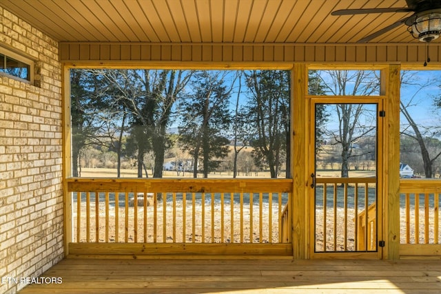 unfurnished sunroom with ceiling fan and wood ceiling