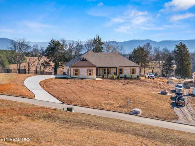 ranch-style house with a mountain view and a front lawn