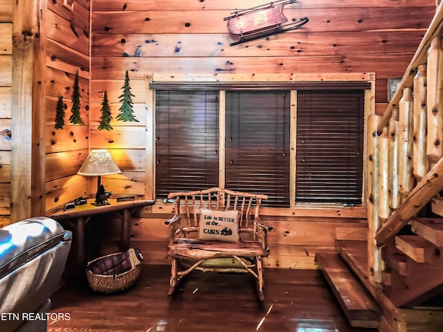 sitting room with wood walls and hardwood / wood-style floors