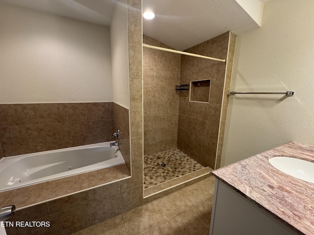 bathroom with a whirlpool tub, tile patterned flooring, vaulted ceiling, a tile shower, and vanity