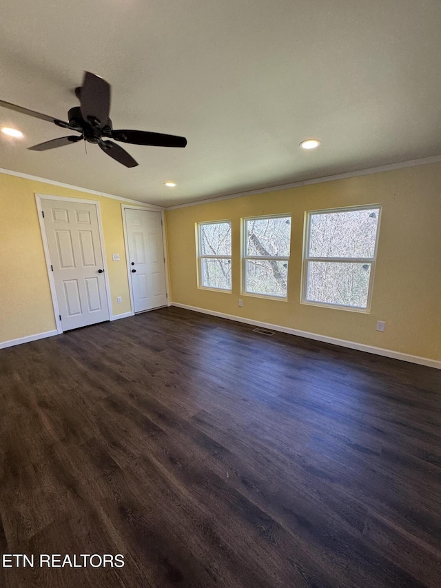 unfurnished bedroom with ornamental molding, baseboards, visible vents, and dark wood-type flooring