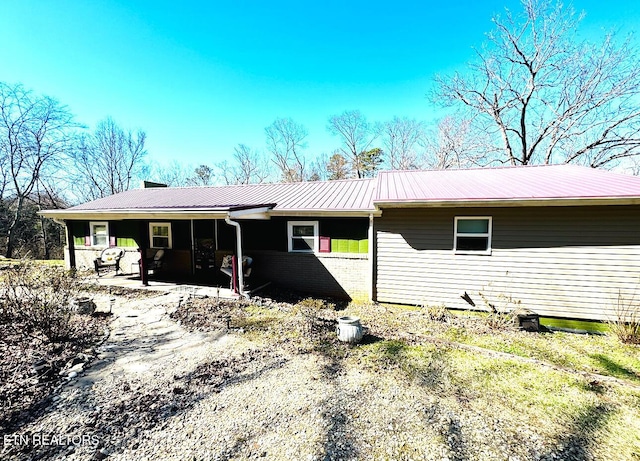 exterior space featuring metal roof and brick siding