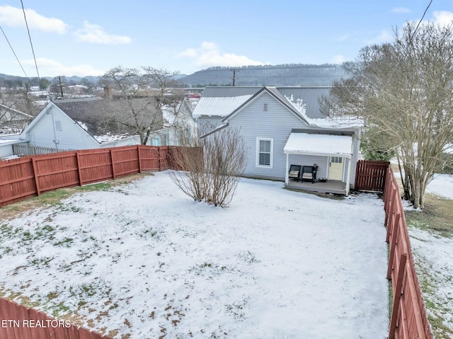 snow covered property with a deck with mountain view