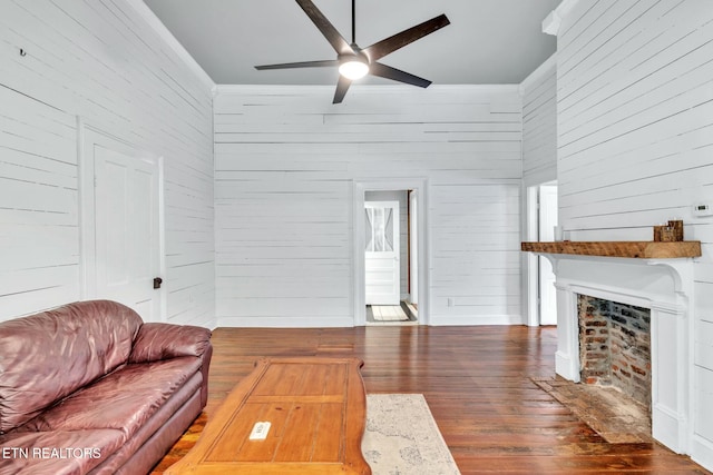 living room with dark hardwood / wood-style floors, wooden walls, and ceiling fan