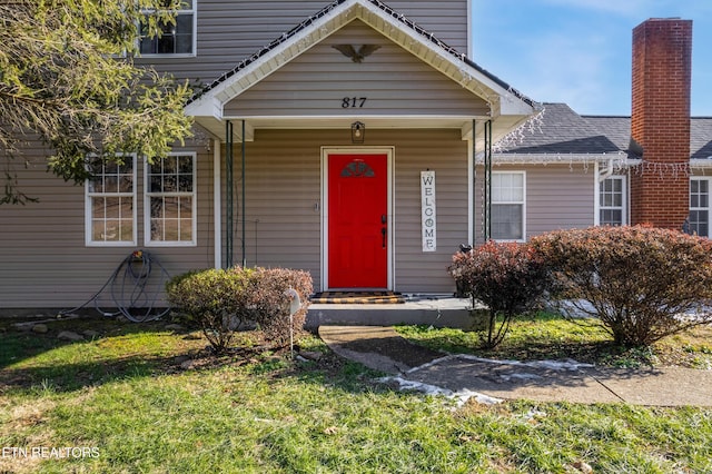 entrance to property with a lawn