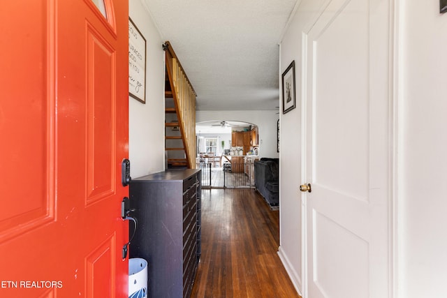 hallway featuring a textured ceiling and dark hardwood / wood-style floors