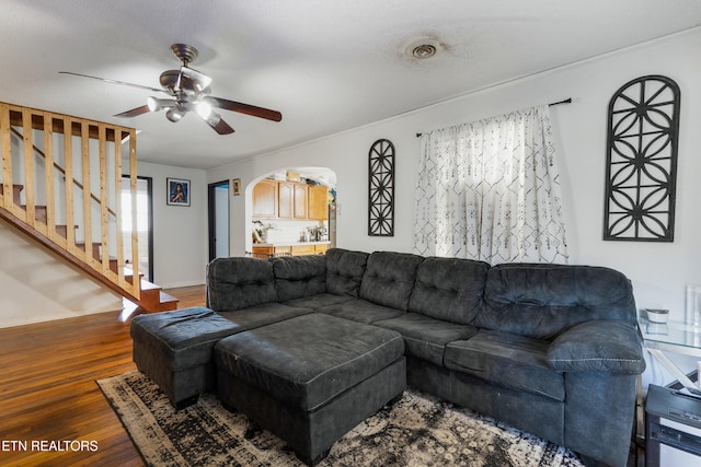 living room featuring ceiling fan, a textured ceiling, and wood-type flooring