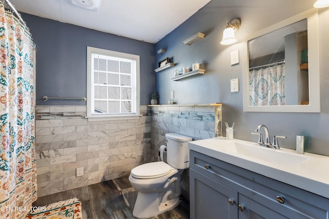 bathroom featuring toilet, hardwood / wood-style floors, a shower with shower curtain, tile walls, and vanity