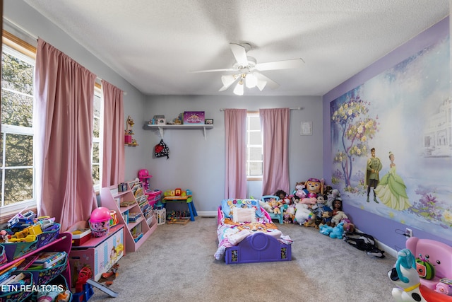 rec room featuring carpet floors, ceiling fan, and a textured ceiling