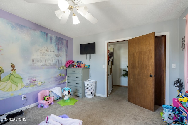 game room featuring ceiling fan, light colored carpet, and a textured ceiling