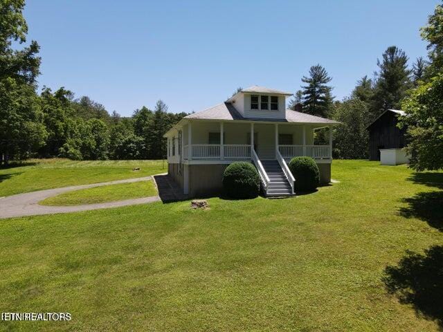 view of front of house with a front yard and a porch