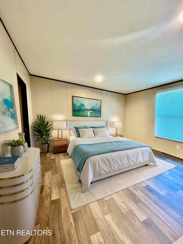 bedroom featuring a textured ceiling and light hardwood / wood-style floors