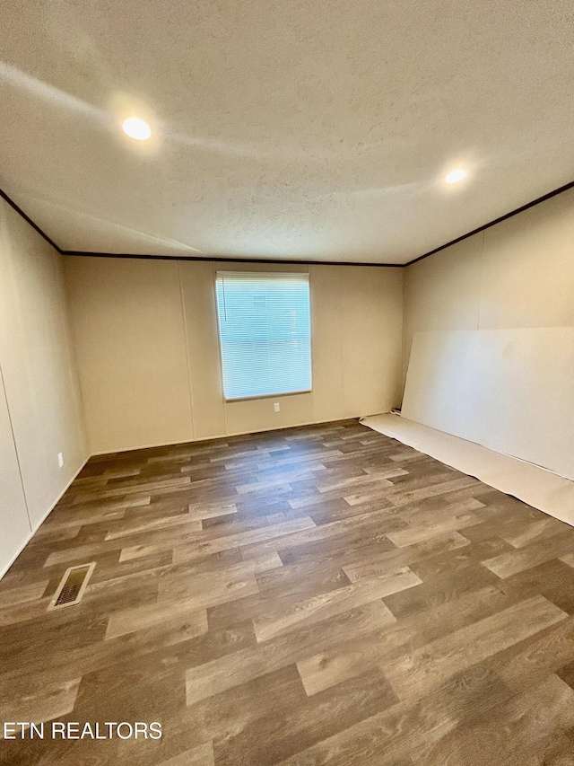 spare room with wood-type flooring and a textured ceiling