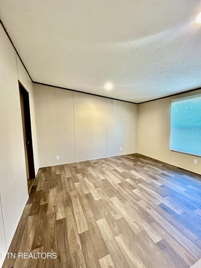 spare room featuring a textured ceiling and hardwood / wood-style floors