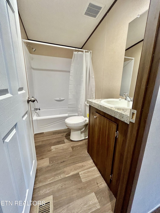 full bathroom with hardwood / wood-style flooring, toilet, vanity, and shower / bath combo