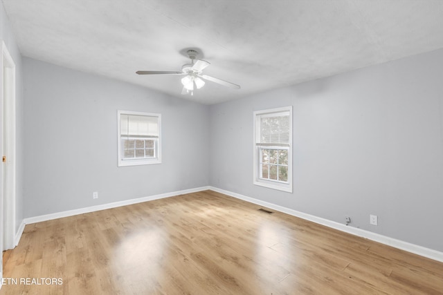 spare room featuring lofted ceiling, light wood-type flooring, and ceiling fan