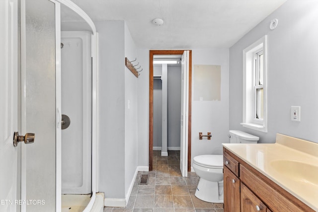 bathroom featuring vanity, walk in shower, and toilet