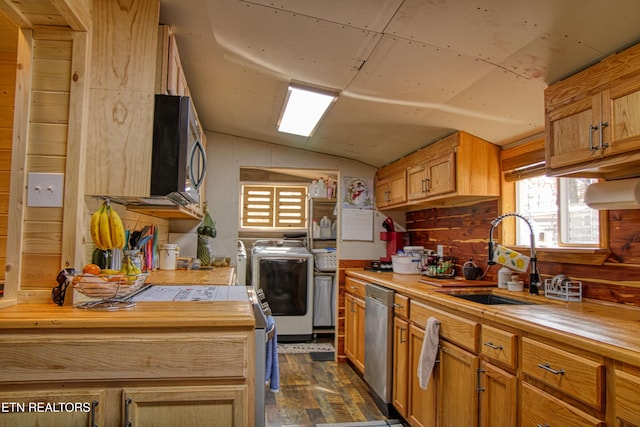 kitchen with stainless steel appliances, washing machine and clothes dryer, butcher block countertops, and sink