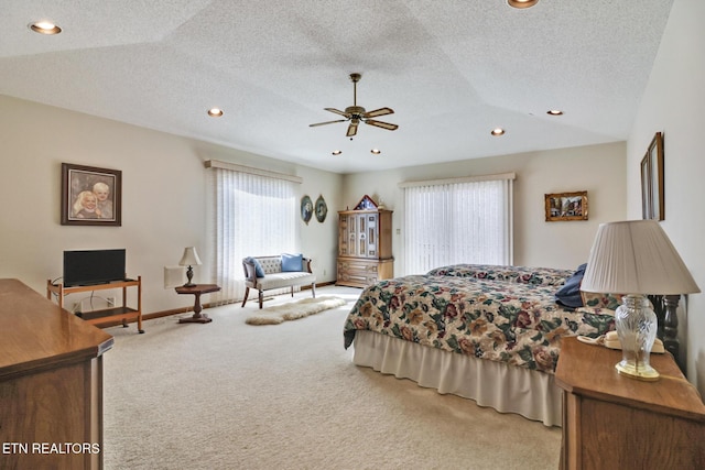 bedroom featuring ceiling fan, lofted ceiling, carpet, and a textured ceiling