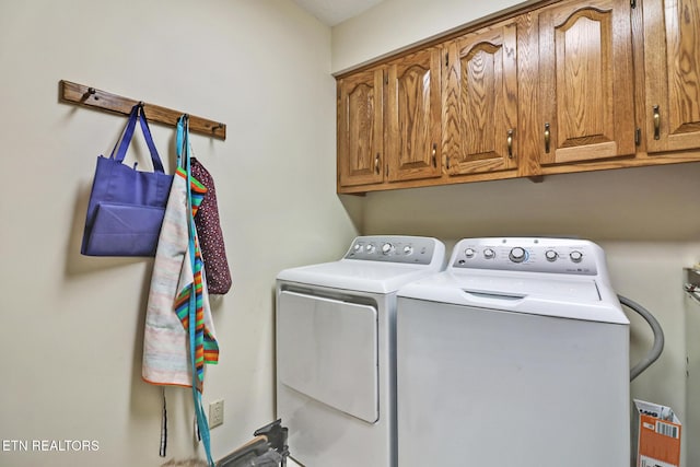 laundry room featuring washing machine and dryer and cabinets