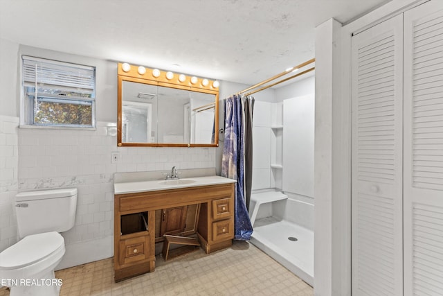 bathroom with tile walls, toilet, a shower with curtain, and vanity