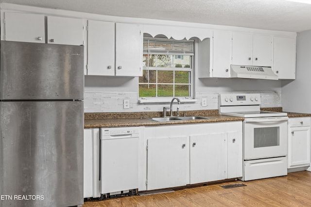 kitchen with white appliances, light wood-type flooring, a textured ceiling, sink, and white cabinetry