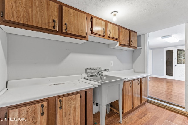 kitchen featuring a textured ceiling and light hardwood / wood-style floors