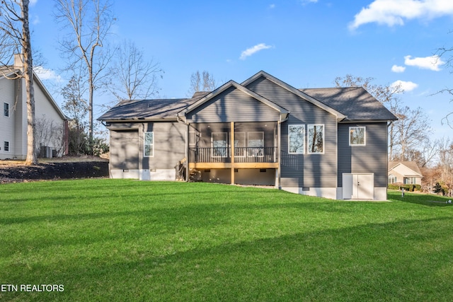 rear view of property featuring a sunroom and a lawn