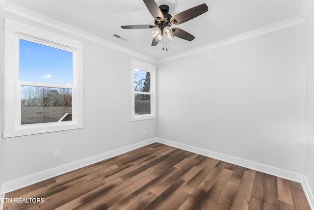 spare room featuring ceiling fan, dark hardwood / wood-style flooring, ornamental molding, and a healthy amount of sunlight