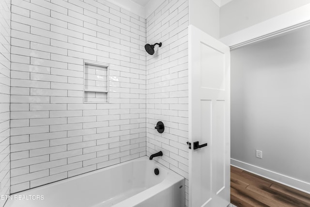 bathroom featuring tiled shower / bath combo and wood-type flooring