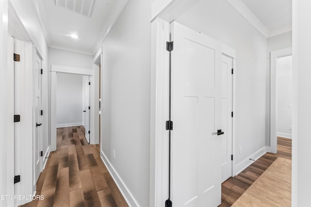 corridor with dark wood-type flooring and crown molding