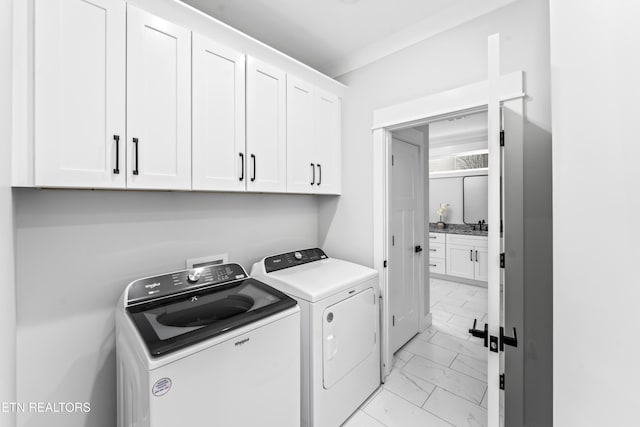 washroom featuring cabinets, washer and dryer, and ornamental molding