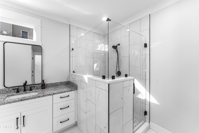 bathroom featuring a shower with shower door and vanity