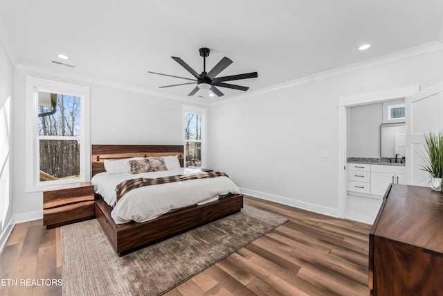 bedroom featuring ceiling fan, crown molding, ensuite bathroom, and hardwood / wood-style flooring