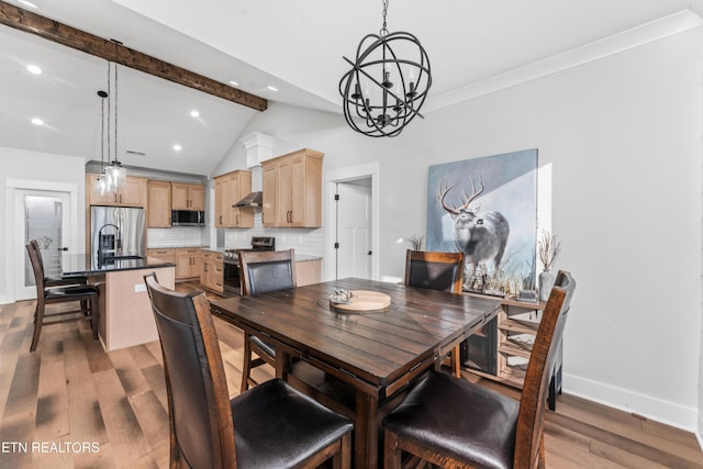 dining room featuring vaulted ceiling with beams, light wood-type flooring, sink, and a chandelier