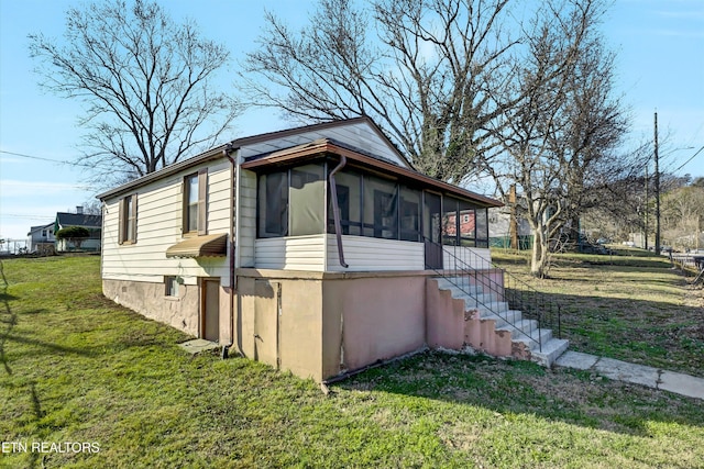 view of home's exterior featuring a yard and a sunroom