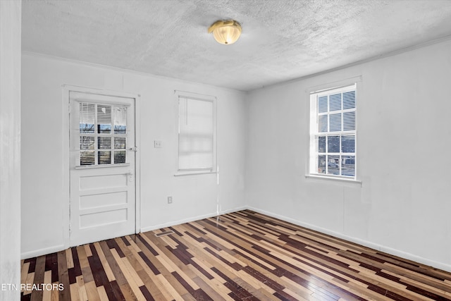 spare room featuring a textured ceiling and hardwood / wood-style floors