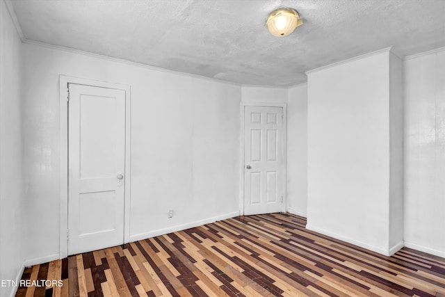 empty room with hardwood / wood-style flooring and a textured ceiling