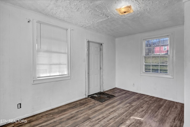 unfurnished room with a textured ceiling and dark wood-type flooring