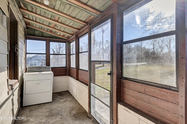 unfurnished sunroom featuring washer / dryer, vaulted ceiling, and a healthy amount of sunlight