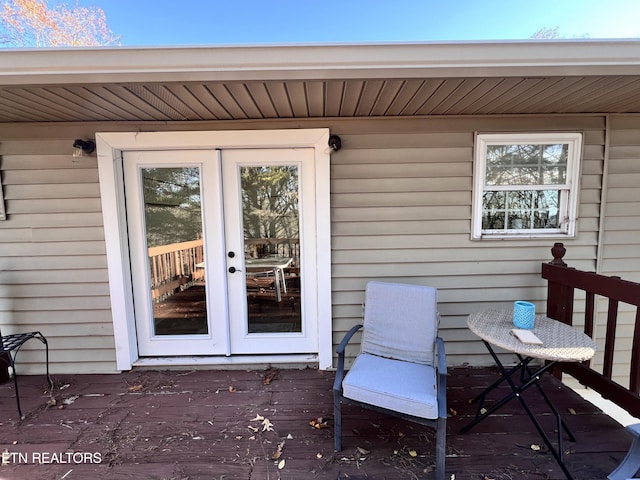 view of exterior entry featuring french doors and a deck