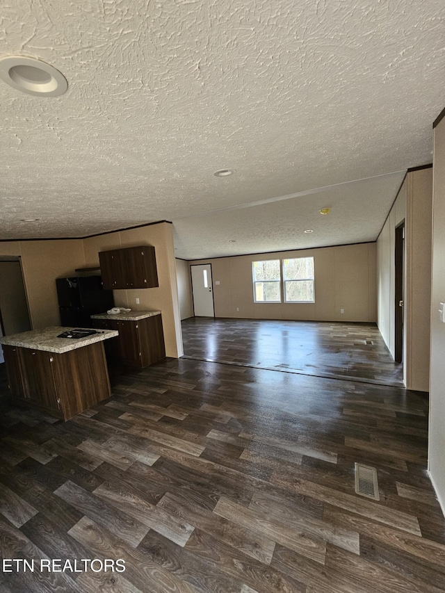 kitchen featuring dark hardwood / wood-style flooring, dark brown cabinets, and a textured ceiling