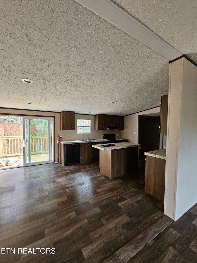 kitchen with a kitchen island, dark hardwood / wood-style floors, and a textured ceiling