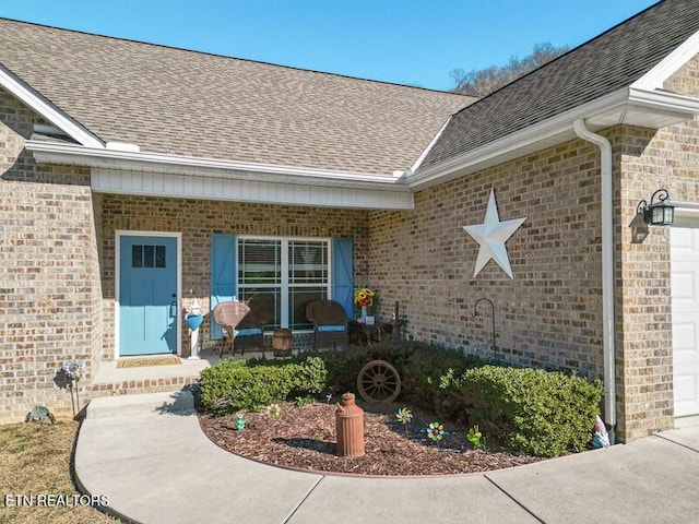 view of exterior entry featuring covered porch and a garage