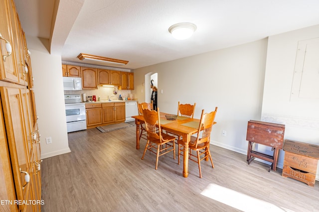 dining room with sink and light hardwood / wood-style flooring