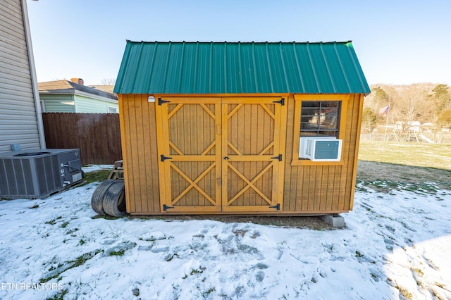 snow covered structure featuring cooling unit