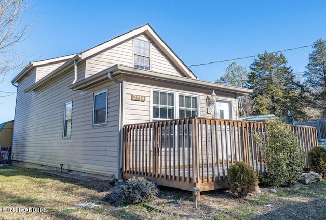 back of house with a deck