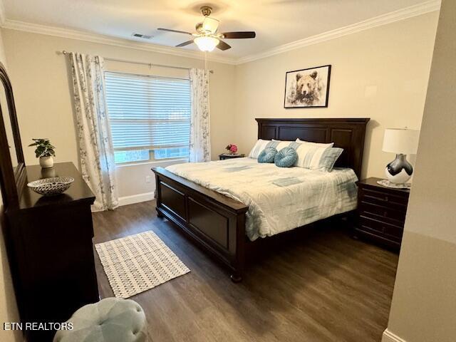 bedroom with crown molding, dark hardwood / wood-style floors, and ceiling fan