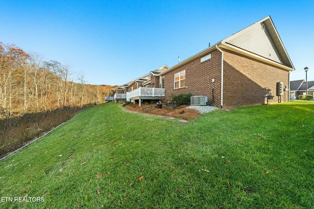 back of property featuring a wooden deck and a yard