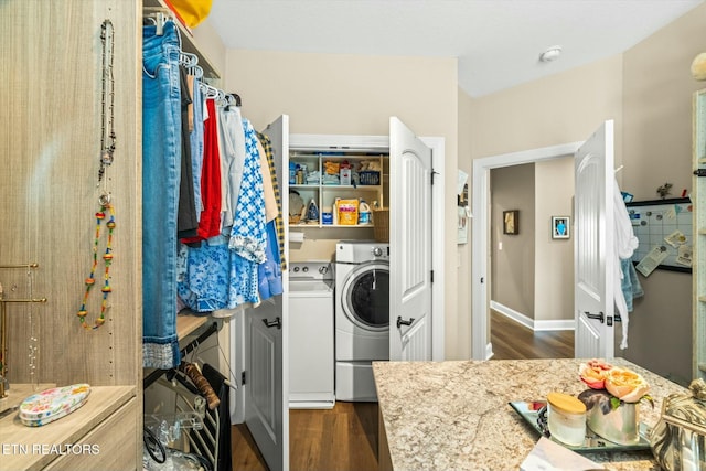 clothes washing area with washer and dryer and dark wood-type flooring